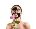 Beautiful young woman with film-type mask and flower on white background
