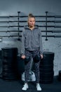 Beautiful young woman fitness instructor wearing a sports suit doing an exercise lunges with dumbbells on a gray Royalty Free Stock Photo