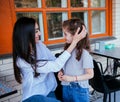 A beautiful young woman fixes her little daughter`s hair. Motherly care and love. Mother`s Day and March 8 Royalty Free Stock Photo