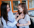 A beautiful young woman fixes her little daughter`s hair. Motherly care and love. Mother`s Day and March 8 Royalty Free Stock Photo