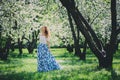 Beautiful young woman in floral maxi skirt walking in spring