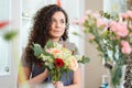 Beautiful young woman florist standing in flower shop Royalty Free Stock Photo