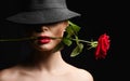 Beautiful young Woman with flower in her mouth. Lovely girl In Hat Royalty Free Stock Photo