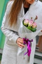 Beautiful young woman with flowers bouquet at city street. Spring portrait of pretty female Royalty Free Stock Photo