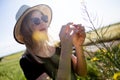 Beautiful young woman with flowers enjoying summer in a field. Royalty Free Stock Photo