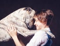 Beautiful young woman with a funny shaggy dog on a dark background. Love, care, friendship