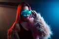 Beautiful young woman in futuristic glasses virtual reality, cyberpunk style, neon light Royalty Free Stock Photo