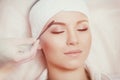 Beautiful young woman gets eyebrow correction procedure Royalty Free Stock Photo