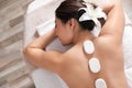 Beautiful young woman getting hot stone massage in spa salon Royalty Free Stock Photo