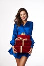 Beautiful young woman with gift in hands. Woman in a blue dress on a white background hold red gift boxes. Holiday shopping Royalty Free Stock Photo