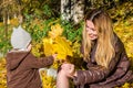 Beautiful young woman girl happy mother playing with her daughter smiling and holding a yellow maple leaves walking in autumn park Royalty Free Stock Photo