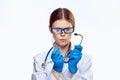 Beautiful young woman in glasses and medical clothes holds a stethoscope on white isolated background, doctor, medicine Royalty Free Stock Photo