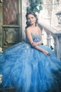 Beautiful young woman in gorgeous blue long dress like Cinderella with perfect make-up and hair style Royalty Free Stock Photo