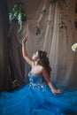 Beautiful young woman in gorgeous blue long dress like Cinderella with perfect make-up and hair style Royalty Free Stock Photo