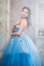 Beautiful young woman in gorgeous blue long dress like Cinderella with perfect make-up and hair style Royalty Free Stock Photo