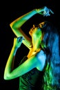 Beautiful young woman in green, blue and yellow lights Royalty Free Stock Photo