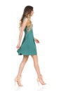 Beautiful Young Woman In Green Mini Dress And High Heels Is Walking. Side View Royalty Free Stock Photo