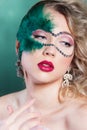 Beautiful young woman in a green mysterious venetian mask a new year carnival, Christmas masquerade, a dance club, secret Royalty Free Stock Photo