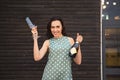 Beautiful young woman in a green polka dots dress holding two glasses and champagne bottle Royalty Free Stock Photo