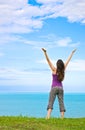 Beautiful young woman greeting the ocean