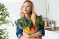 Beautiful young woman grocery shopping bag with vegetables at home. Royalty Free Stock Photo