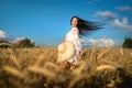 Beautiful young woman with hair wind in the summer wheat field. Summer in countryside Royalty Free Stock Photo