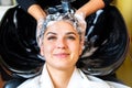 Young woman with hairdresser washing head at hair salon Royalty Free Stock Photo