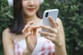 Beautiful young woman hand holding playing using touching smartphone