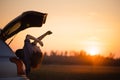 Beautiful young woman happy and dancing in a car`s trunk during a road trip in Europe in the last minutes of Golden Hour Royalty Free Stock Photo