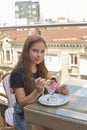 Beautiful young woman happy smiling, looking at camera sitting in restaurant or cafe and eating ice cream Royalty Free Stock Photo