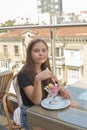 Beautiful young woman happy smiling, looking at camera sitting in restaurant or cafe and eating ice cream Royalty Free Stock Photo