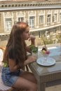 Beautiful young woman happy smiling, looking at camera sitting in restaurant or cafe and eating ice cream Royalty Free Stock Photo