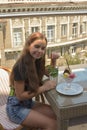 Beautiful young woman happy smiling, looking at camera sitting in restaurant or cafe and eating ice cream Royalty Free Stock Photo