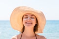 Beautiful young woman in hat is applying sunblock under her eyes and on her nose like Indian. Sun protection concept Royalty Free Stock Photo