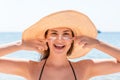 Beautiful young woman in hat is applying sunblock under her eyes and on her nose like Indian. Sun protection concept Royalty Free Stock Photo