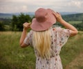 beautiful young woman in a hat and a dress with a bouquet of flowers in the field Royalty Free Stock Photo