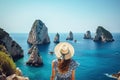 Beautiful young woman in hat looking at the beautiful view of Capri island, Italy, Holidays on Capri Island. Back view of
