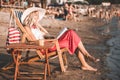 Girl reading a book while sitting on deck chair Royalty Free Stock Photo