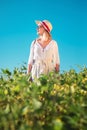 Beautiful young woman with hat standing in field in summer Royalty Free Stock Photo