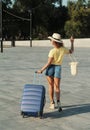 Beautiful young woman in hat with suitcase and wine glass waiting a ship for summer trip. Royalty Free Stock Photo