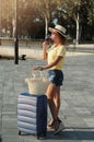 Beautiful young woman in hat with suitcase and wine glass waiting a ship for summer trip. Royalty Free Stock Photo
