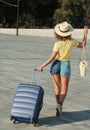 Beautiful young woman in hat with suitcase and wine glass waiting a ship for summer trip. Royalty Free Stock Photo