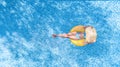 Beautiful young woman in hat in swimming pool aerial top view from above, young girl in bikini relaxes on inflatable ring Royalty Free Stock Photo