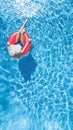 Beautiful young woman in hat in swimming pool aerial top view from above, young girl in bikini relaxes on inflatable ring Royalty Free Stock Photo