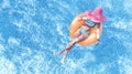 Beautiful young woman in hat in swimming pool aerial top view from above, young girl in bikini relaxes on inflatable ring Royalty Free Stock Photo