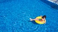 Beautiful young woman in hat in swimming pool aerial top view from above, girl in bikini relaxes and swims on inflatable ring has