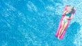 Beautiful young woman in hat in swimming pool aerial top view from above, young girl in bikini relaxes on inflatable ring