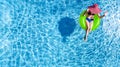 Beautiful young woman in hat in swimming pool aerial top view from above, young girl in bikini relaxes on inflatable ring Royalty Free Stock Photo