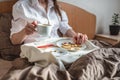 Woman have a romantic Breakfast in cozy morning bed. Coffee and word love from cookies. Surprise on Valentine`s day Royalty Free Stock Photo