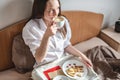 Young woman have a romantic Breakfast in morning bed. Coffee and word love from cookies. Surprise on Valentine`s day Royalty Free Stock Photo